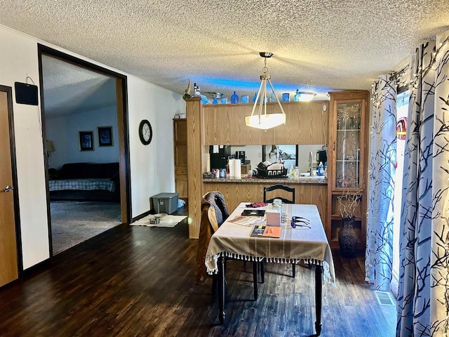 dining room featuring dark hardwood / wood-style flooring and a textured ceiling