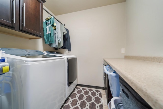 laundry area with washer and dryer and cabinets