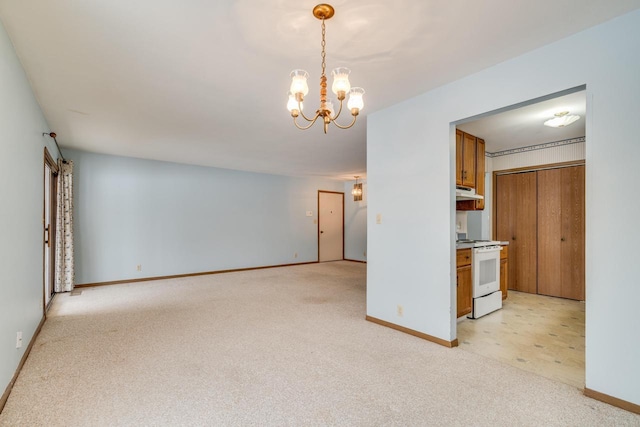 empty room featuring a chandelier and light colored carpet