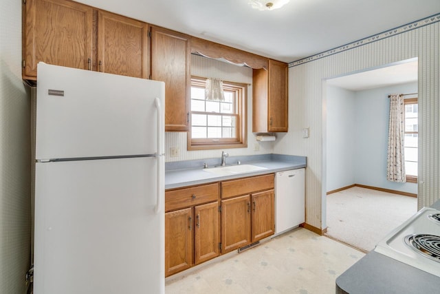 kitchen with white appliances, plenty of natural light, and sink