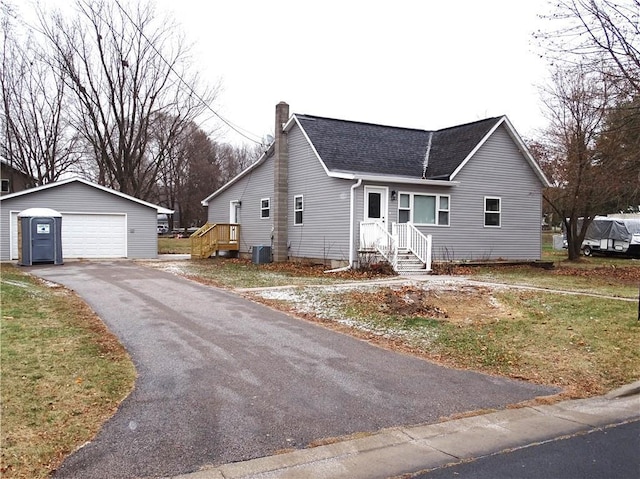 view of front of house featuring a garage, an outdoor structure, and central air condition unit