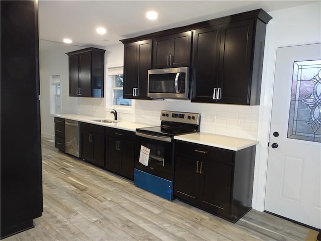 kitchen featuring light hardwood / wood-style floors, sink, stainless steel appliances, and tasteful backsplash