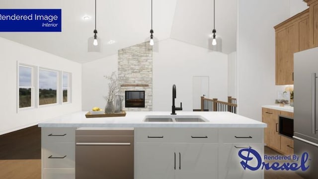 kitchen featuring decorative light fixtures, sink, white cabinetry, and an island with sink