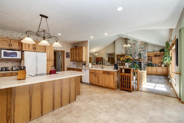 kitchen featuring white appliances, sink, pendant lighting, a chandelier, and lofted ceiling