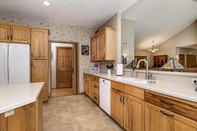 kitchen featuring pendant lighting, lofted ceiling, white appliances, an inviting chandelier, and sink