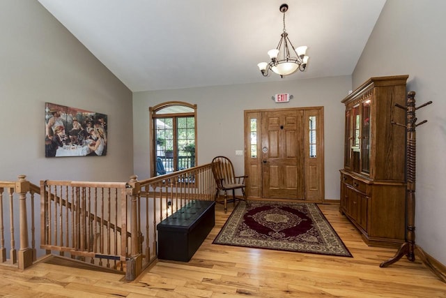 foyer featuring light hardwood / wood-style flooring, vaulted ceiling, and an inviting chandelier