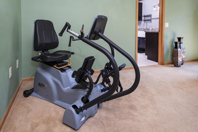 workout room featuring light carpet