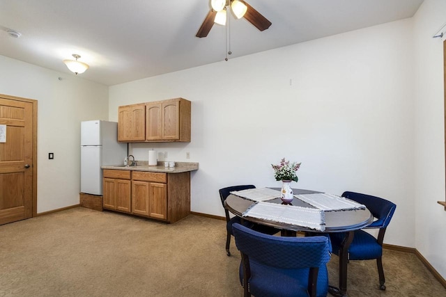 carpeted dining room featuring ceiling fan and sink