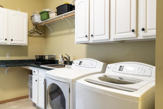 laundry room with cabinets, washing machine and clothes dryer, and sink