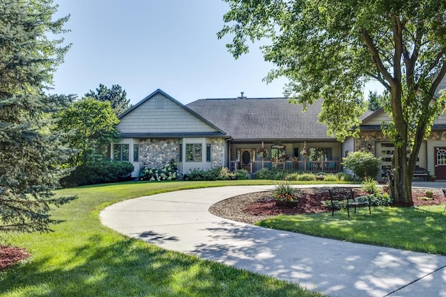 view of front facade featuring covered porch and a front yard