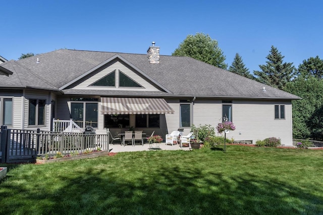 rear view of house with a patio and a lawn