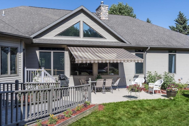 back of house with a lawn and a patio