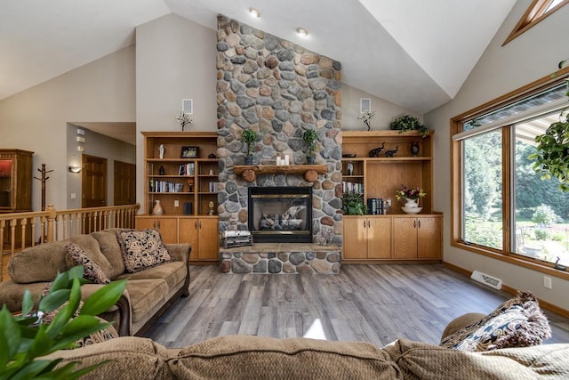 living room with a fireplace, high vaulted ceiling, and light hardwood / wood-style flooring