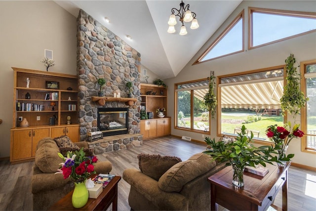 living room featuring a fireplace, high vaulted ceiling, a chandelier, and hardwood / wood-style flooring