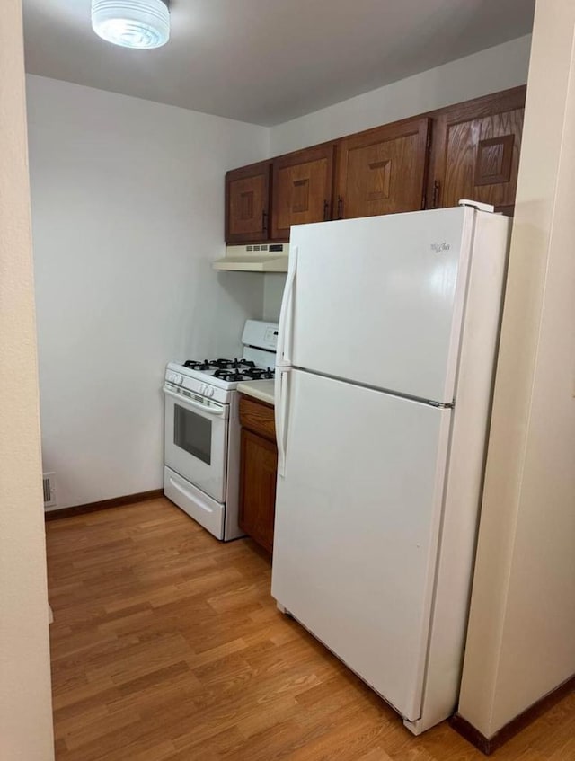 kitchen featuring light wood-type flooring and white appliances