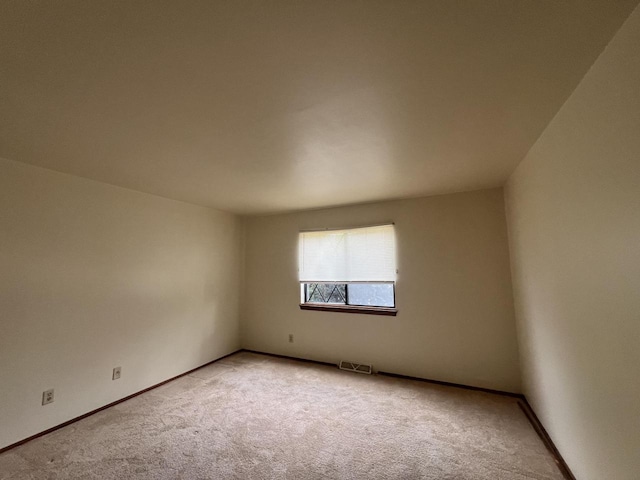 unfurnished room featuring light carpet