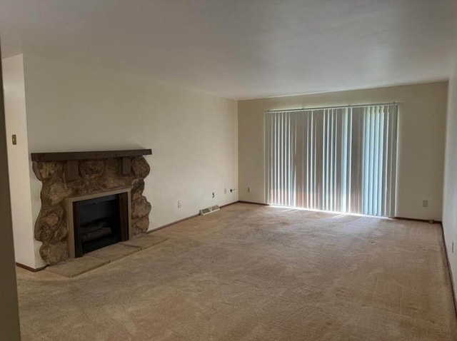 unfurnished living room featuring carpet and a fireplace