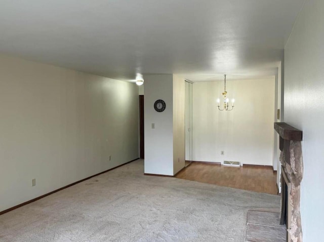 carpeted empty room featuring a notable chandelier