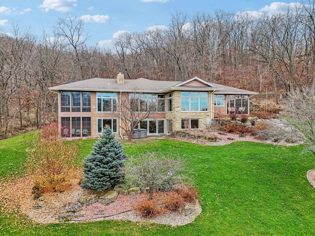 back of house featuring a yard and a sunroom