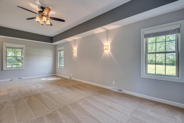 carpeted empty room featuring ceiling fan and a healthy amount of sunlight