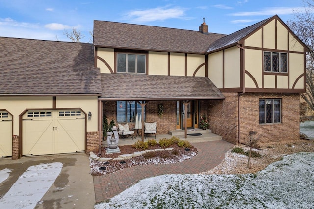 english style home with a porch and a garage