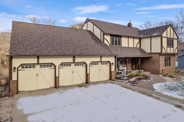 tudor house featuring a porch and a garage