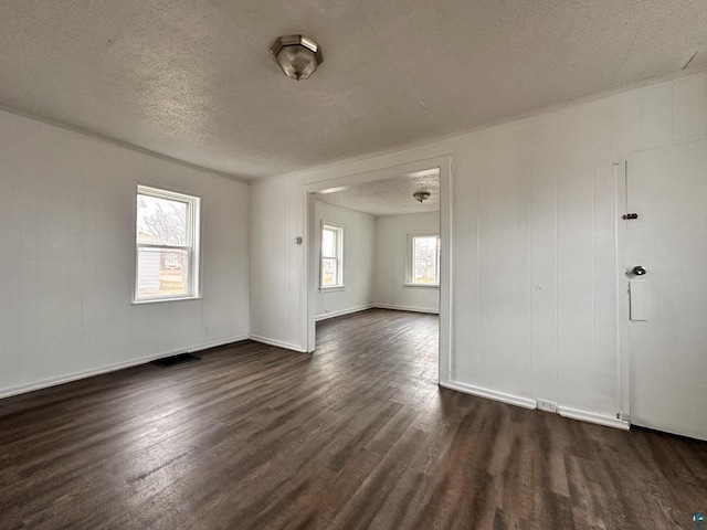 empty room featuring a textured ceiling and dark wood-type flooring