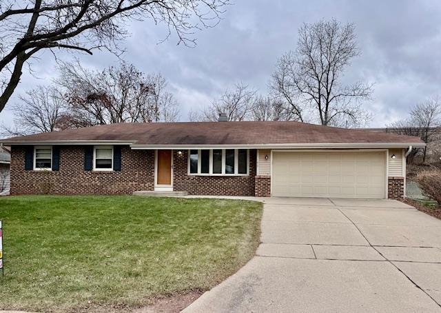 ranch-style house featuring a front yard and a garage