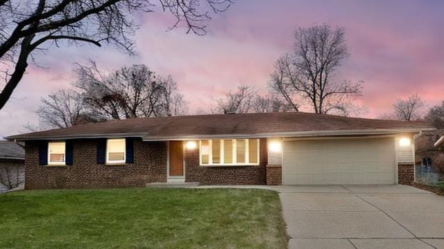 ranch-style home featuring a lawn and a garage