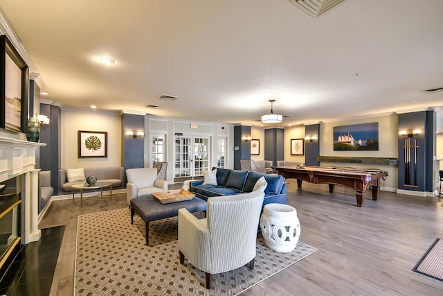 living room featuring hardwood / wood-style floors, french doors, billiards, ornamental molding, and a textured ceiling