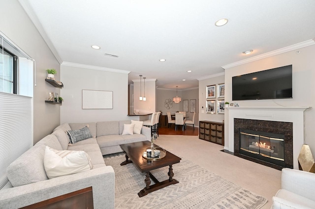 carpeted living room featuring crown molding and a fireplace