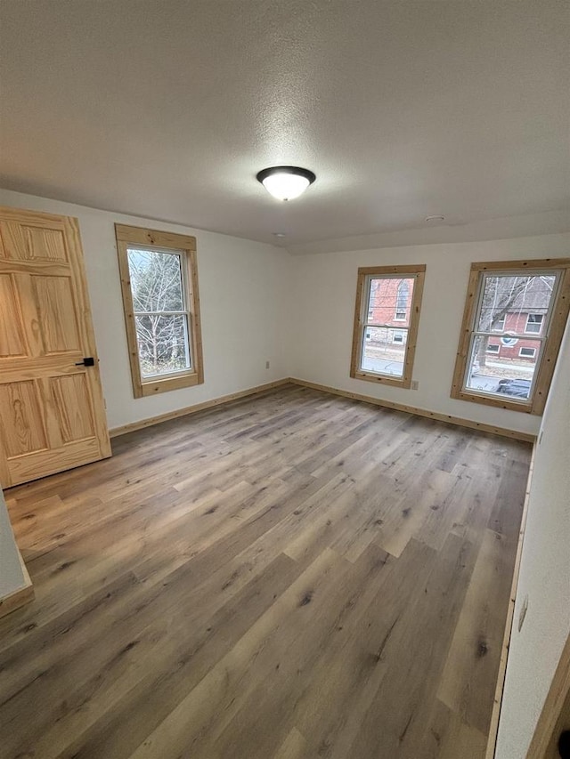 unfurnished room featuring wood-type flooring and a textured ceiling