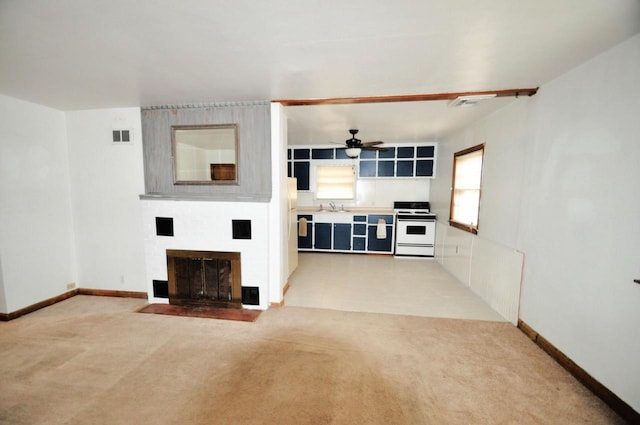 unfurnished living room with ceiling fan, sink, and light carpet