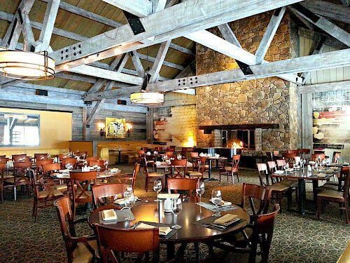 carpeted dining space with beam ceiling, high vaulted ceiling, and wooden ceiling