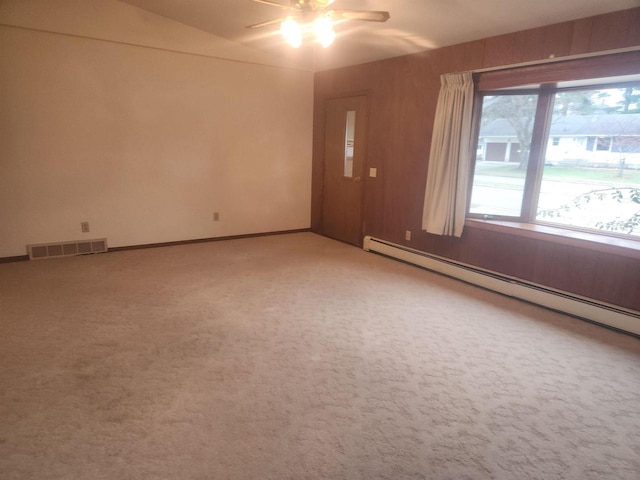 carpeted empty room featuring ceiling fan, a baseboard radiator, and vaulted ceiling