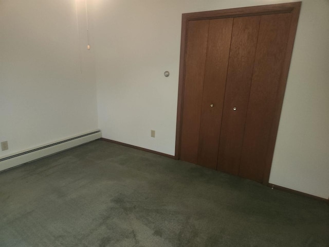 unfurnished bedroom featuring baseboard heating, a closet, and dark colored carpet