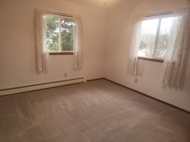 carpeted empty room with a healthy amount of sunlight and baseboard heating