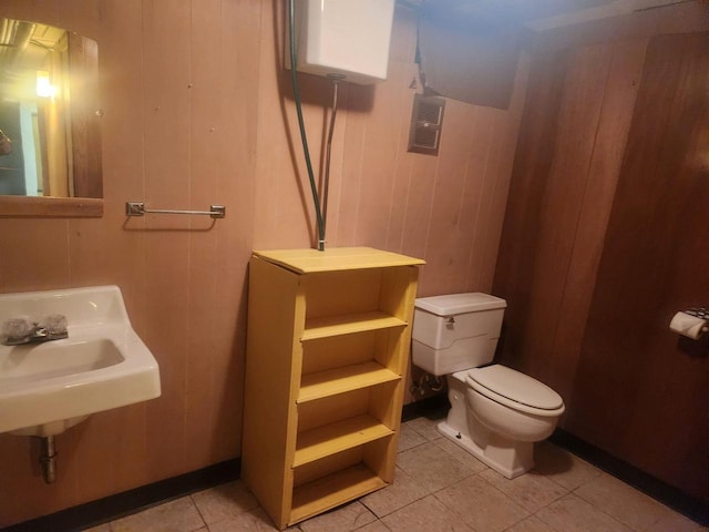 bathroom featuring wooden walls, tile patterned flooring, and toilet