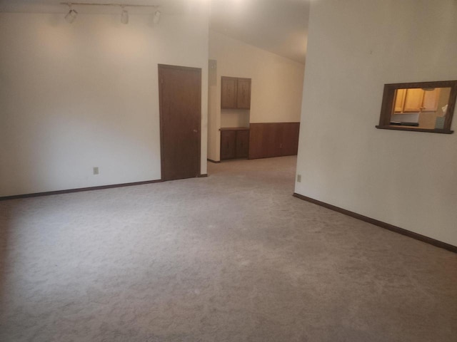 empty room with light colored carpet and lofted ceiling