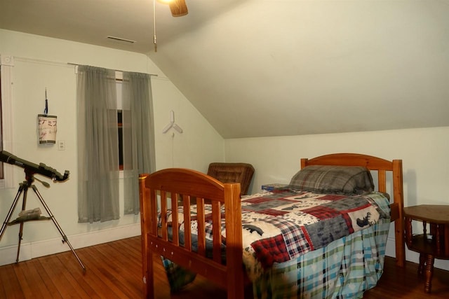 bedroom with ceiling fan, dark wood-type flooring, and vaulted ceiling