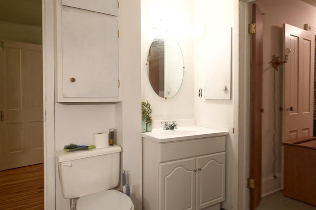 bathroom with hardwood / wood-style flooring, vanity, and toilet