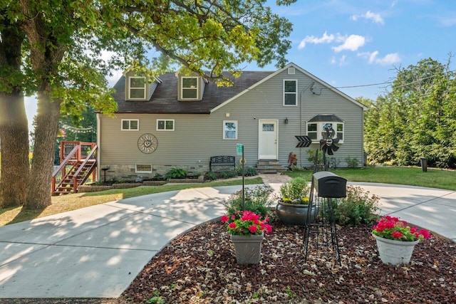 cape cod home featuring a front yard