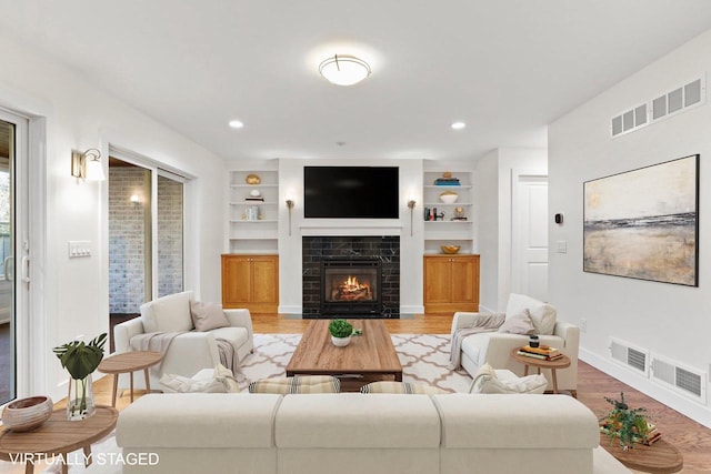 living room with built in features and hardwood / wood-style flooring