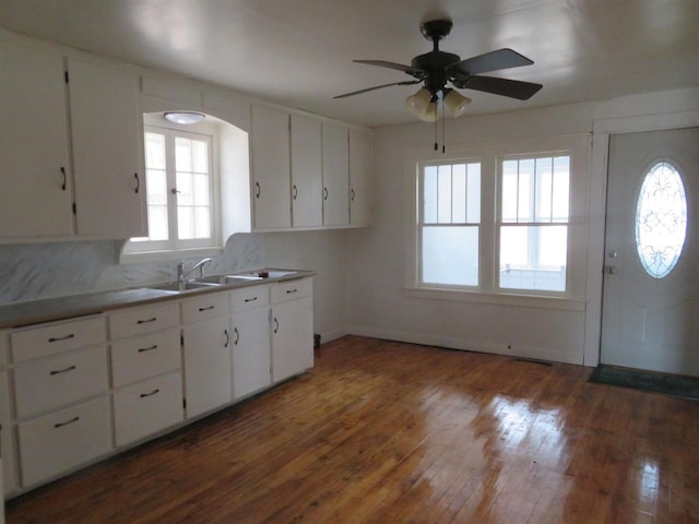 kitchen with white cabinets, dark hardwood / wood-style flooring, sink, and a wealth of natural light