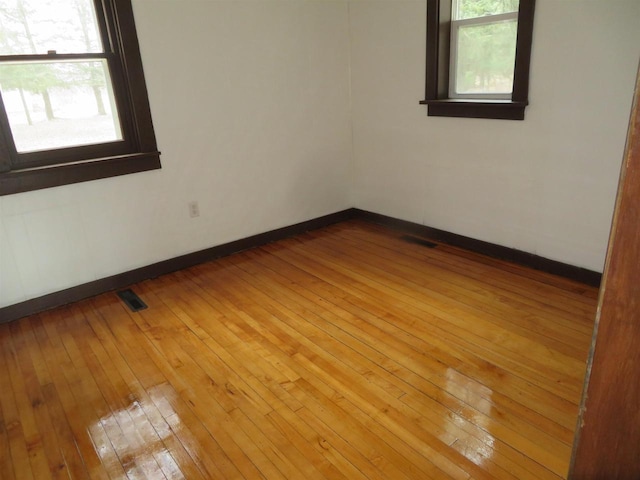 spare room featuring light hardwood / wood-style flooring and a healthy amount of sunlight