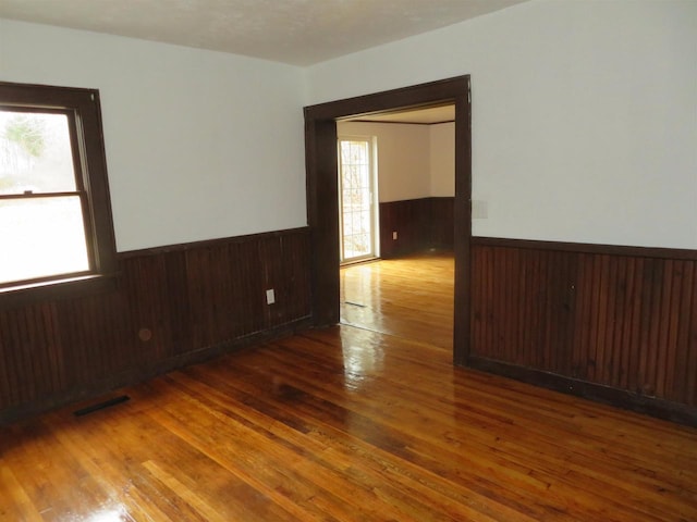 empty room featuring wood walls and dark hardwood / wood-style floors