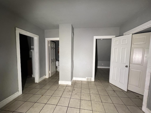 unfurnished bedroom featuring light tile patterned floors and a closet