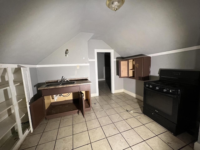 kitchen with gas stove, light tile patterned floors, sink, and vaulted ceiling