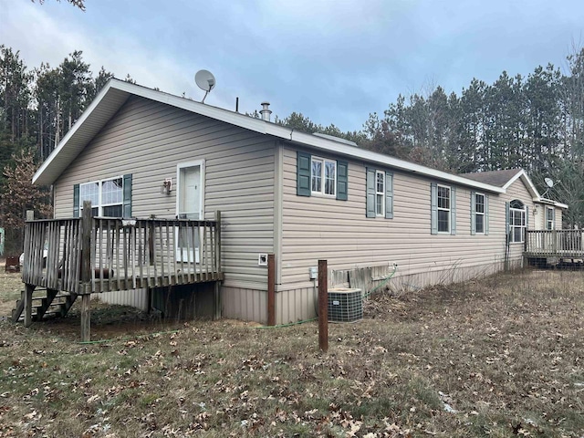 rear view of house featuring central air condition unit and a wooden deck