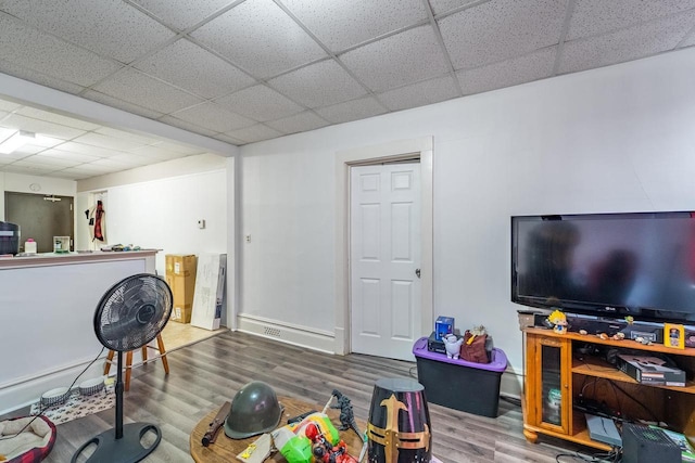 game room with hardwood / wood-style floors and a drop ceiling